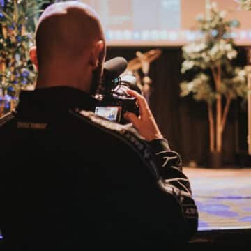 Foto van een cameraman die een cursus muziekproductie vastlegt in Patronaat.