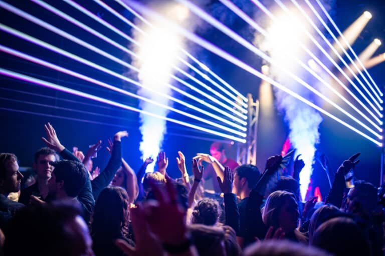 Publiek gooit de handen omhoog bij een DJ
